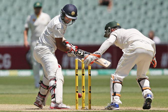 Cheteshwar Pujara India is bowled by Nathan Lyon as wicket keeper Brad Haddin celebrates