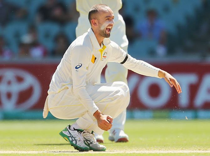 Nathan Lyon celebrates after taking a catch off his own bowling to dismiss Rohit Sharma