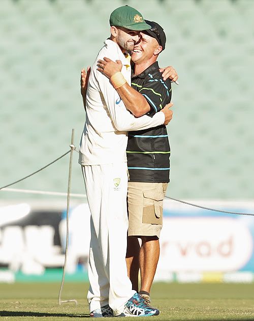 Nathan Lyon of Australia is embraced by Adelaide Oval's head curator Damian Hough