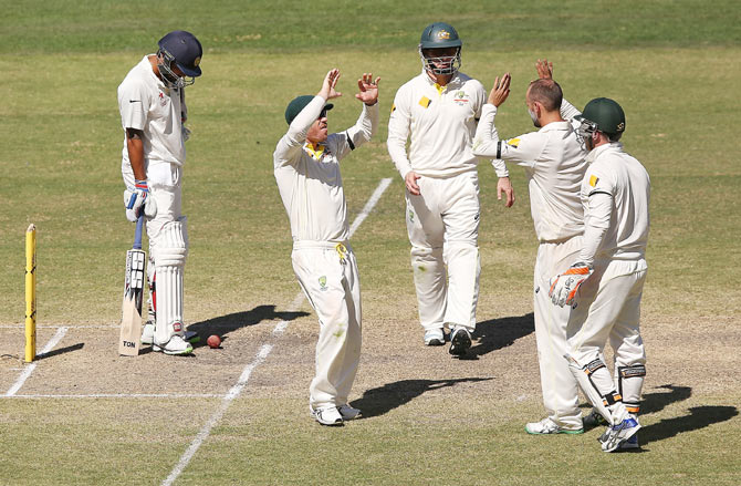 Nathan Lyon (right) celebrates the wicket of Murali Vijay