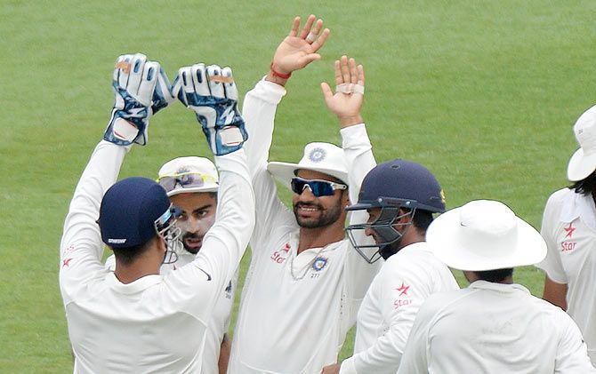 Shikhar Dhawan celebrates with teammates after taking a catch to dismiss Shane Watson