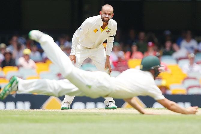 Nathan Lyon of Australia watches substitute fielder Marnus Labuschagne take a catch to dismiss Varun Aaron