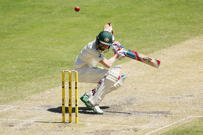 Nathan Lyon of Australia ducks under a ball 