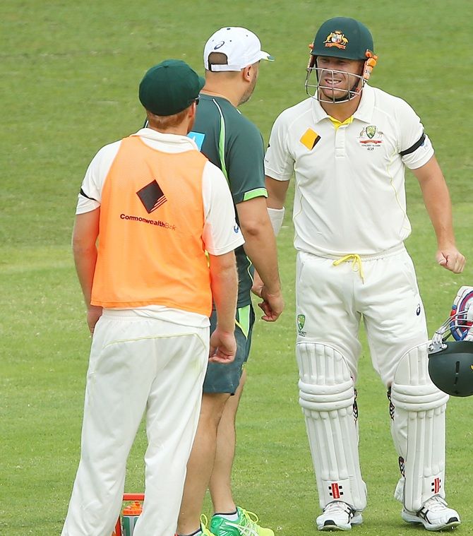 David Warner of Australia injures his hand after the ball hit it during day four of the second Test match between Australia and India at The Gabba 