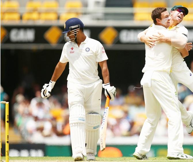 Josh Hazlewood of Australia celebrates with team mate David Warner after   dismissing Mahendra Singh Dhoni