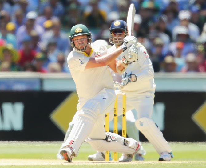 Ryan Harris hits a six as MS Dhoni of India looks on