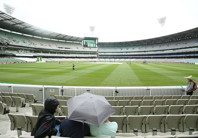 Fans wait as rain delays play during day four of the third Test match