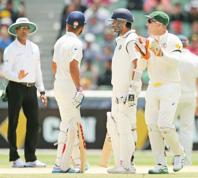 Brad Haddin of Australia exchanges words with batsman Murali Vijay and Virat Kohli of India as   umpire Kumar Dharmasena speaks to them during Day five of the third Test