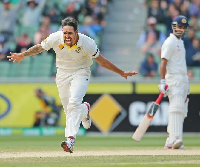 Mitchell Johnson of Australia celebrates after bowling Cheteshwar Pujara 