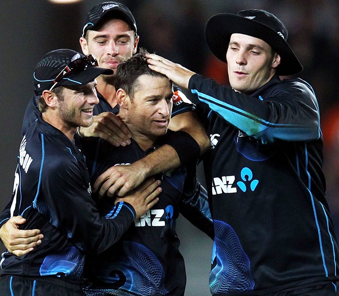 Nathan McCullum (centre) of New Zealand is congratulated by teammates