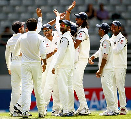 The Indian cricket team celebrates the fall of a wicket
