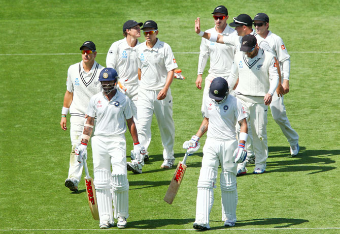 Shikhar Dhawan (left) of India leaves the field after being dismissed for 98