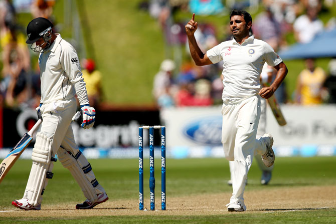 Mohammed Shami of India celebrates his wicket of Tom Latham of New Zealand (left)