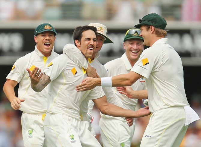 Mitchell Johnson celebrates a wicket with teammates