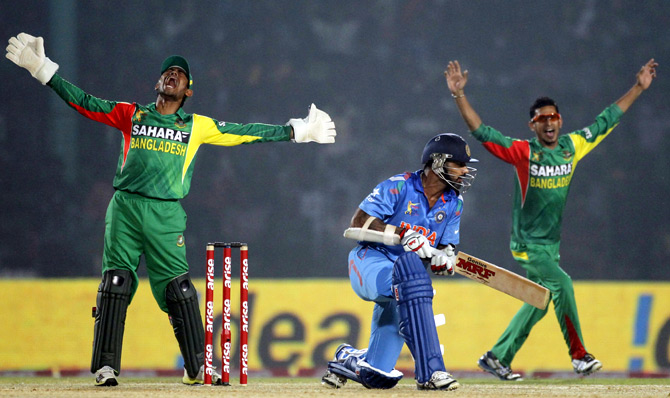 Bangladesh's wicketkeeper Anamul Haque (left) and Nasir Hossain appeal for the dismissal of Shikhar Dhawan (centre)