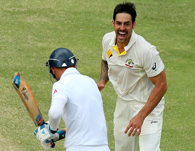 Mitchell Johnson (right) celebrates after taking the wicket of Stuart Broad