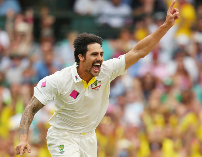 Mitchell Johnson of Australia celebrates taking the wicket of Michael Carberry of England