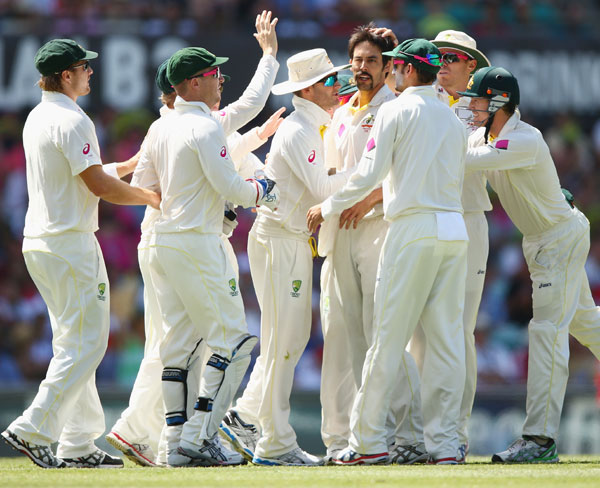 Mitchell Johnson of Australia celebrates with teammates after dismissing James Anderson of England during day two of Sydney Test