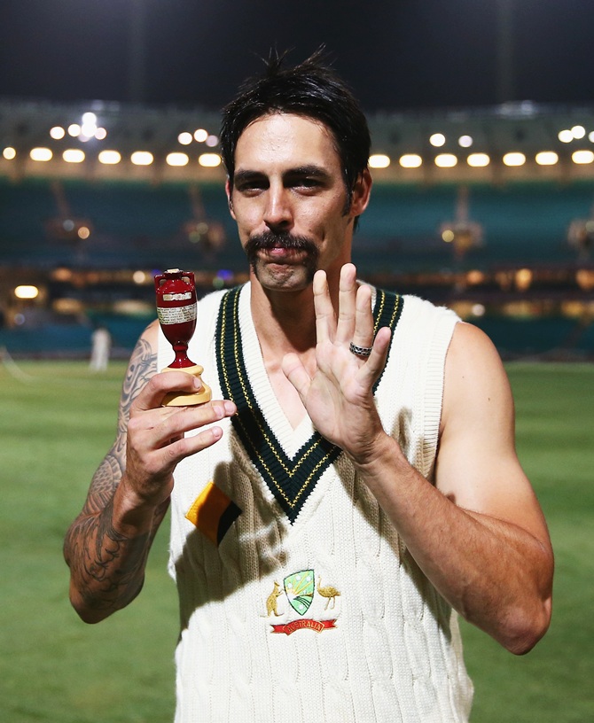Mitchell Johnson of Australia poses with the Ashes Urn on the pitch