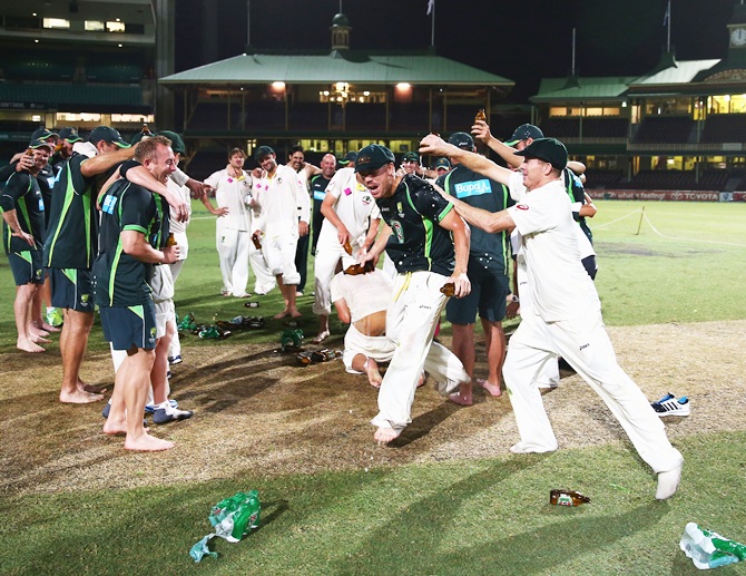 Chris Rogers of Australia pours beer on David Warner of Australia before singing the team song on the pitch