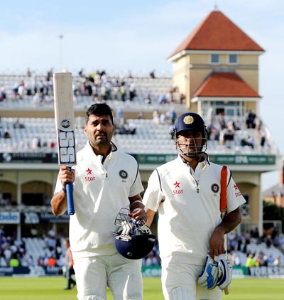 Murali Vijay of India raises his bat as he leaves the field alongside Mahendra Singh Dhoni