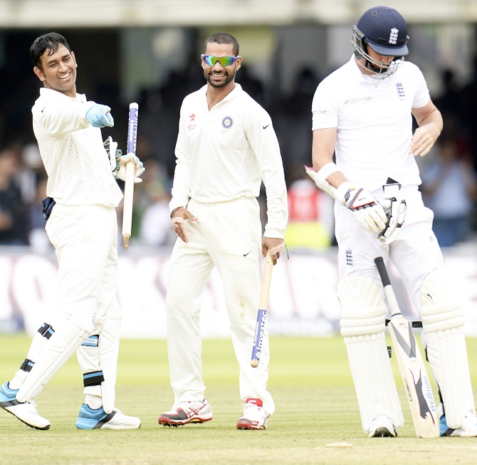 Mahendra Singh Dhoni, left, and Shikhar Dhawan watch England's James  Anderson, right, depart after India won the second Test at Lord's