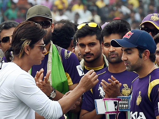 Kolkata Knight Riders owner Shahrukh Khan interacts with captain Gautam Gambhir and other players during a felicitation