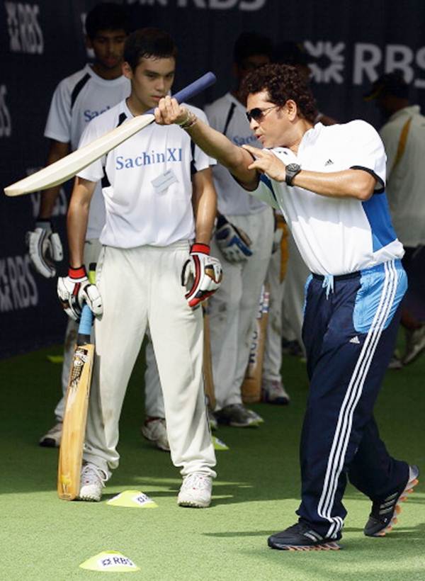 Sachin Tendulkar explains how to execute a shot during a session with young cricketers at the Singapore Cricket Club.