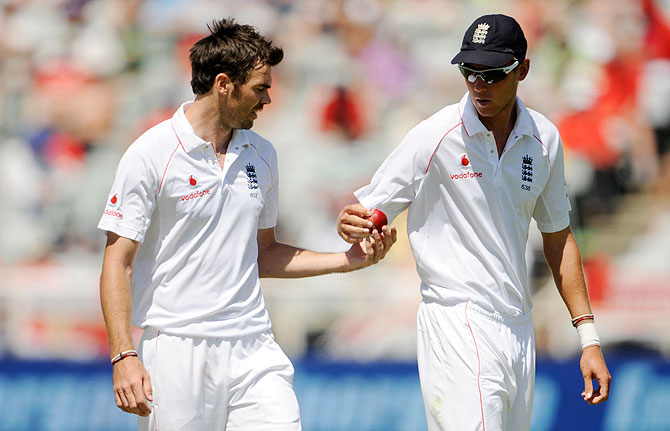 England's James Anderson (left) hands the ball to teammate Stuart Broad during the third Test against South Africa at Newlands in Cape Town on January 6, 2010