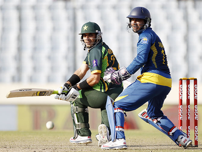 Pakistan's captain Misbah-ul-Haq plays a shot as Sri Lanka's wicketkeeper Kumar Sangakkara watches on Saturday.
