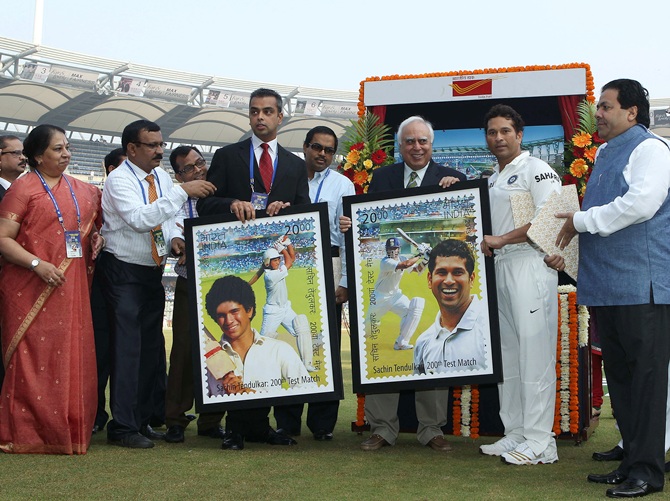 Sachin Tendulkar poses with the framed versions of the  stamp produced in his honour