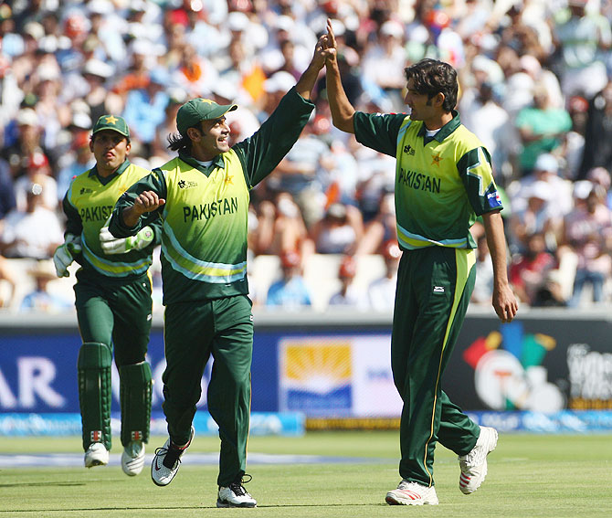 Sohail Tanveer is congratulated by his Pakistan teammates after taking the wicket of Robin Uthappa