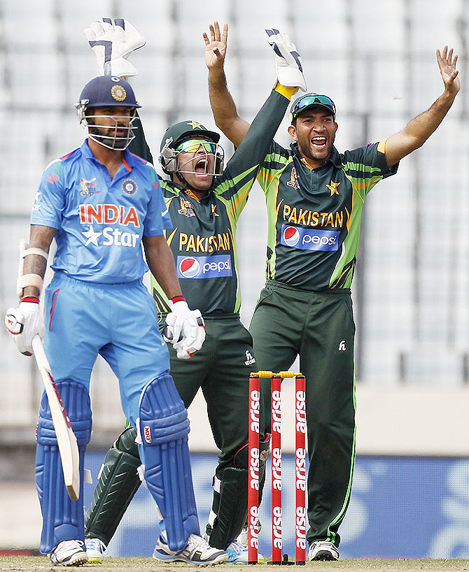 India's Shikhar Dhawan reacts on being dismissed as Pakistan's wicketkeeper Umar Akmal (centre) and Sohaib Maqsood (right) appeal successful 