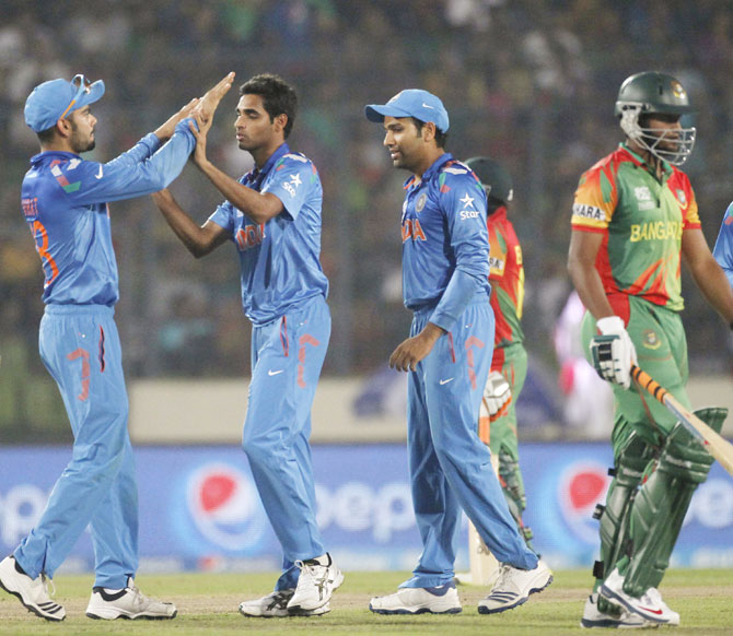 Bangladesh's Shakib Al Hasan leaves the field as India's fielders congratulate Bhuvneshwar Kumar (3rd left) on dismissing him