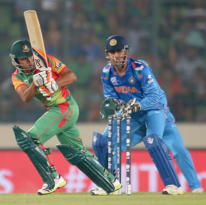 Anamul Haque of Bangladesh bats as MS Dhoni of India looks