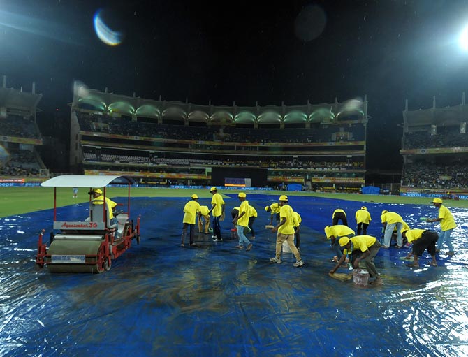 Ground staff perform mopping up operations after rain lashed the JSCA International Stadium in Ranchi