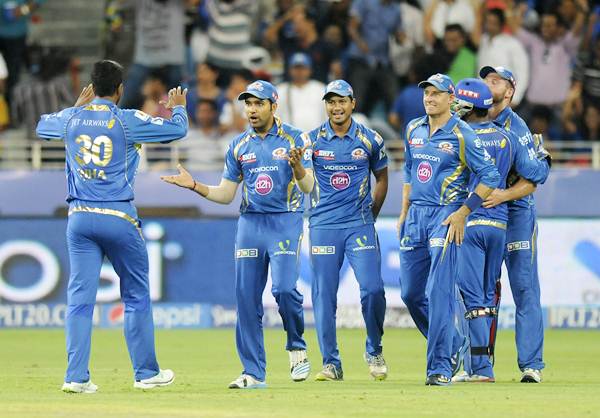 Mumbai Indians players celebrate the fall of a wicket