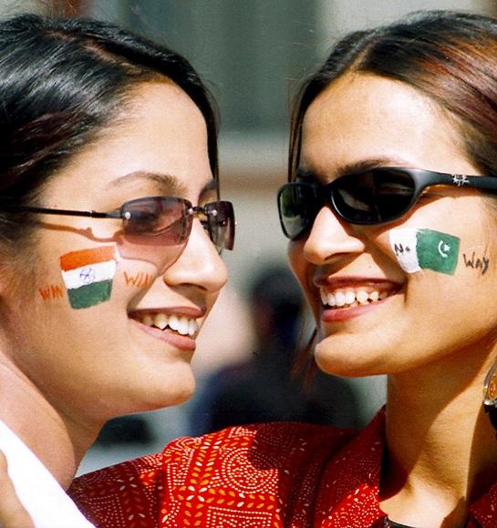 Indian cricket fans with their faces painted with national flags of India (left) and Pakistan