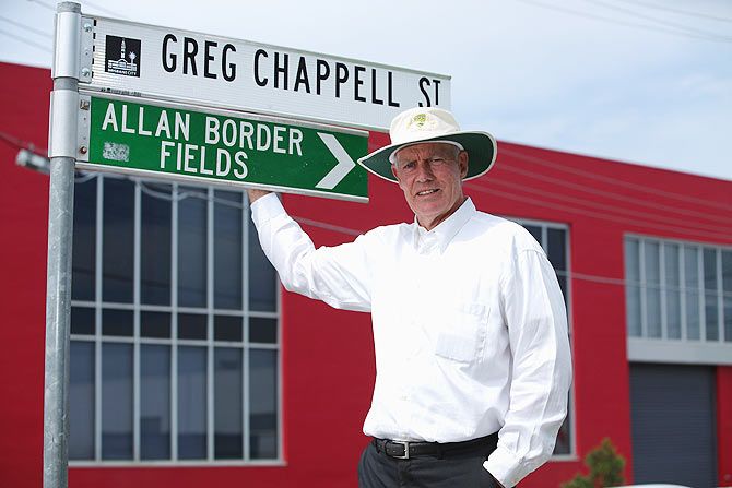 Greg Chappell poses for a photograph with the street sign named after him at the National Cricket Centre in Brisbane, Australia