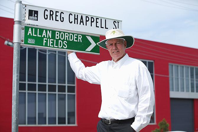 Greg Chappell poses for a photograph with the street sign named after him at the National Cricket Centre in Brisbane, Australia