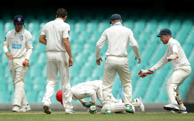 Phillip Hughes falls to the ground after being struck by a short delivery from fast bowler Sean Abbott