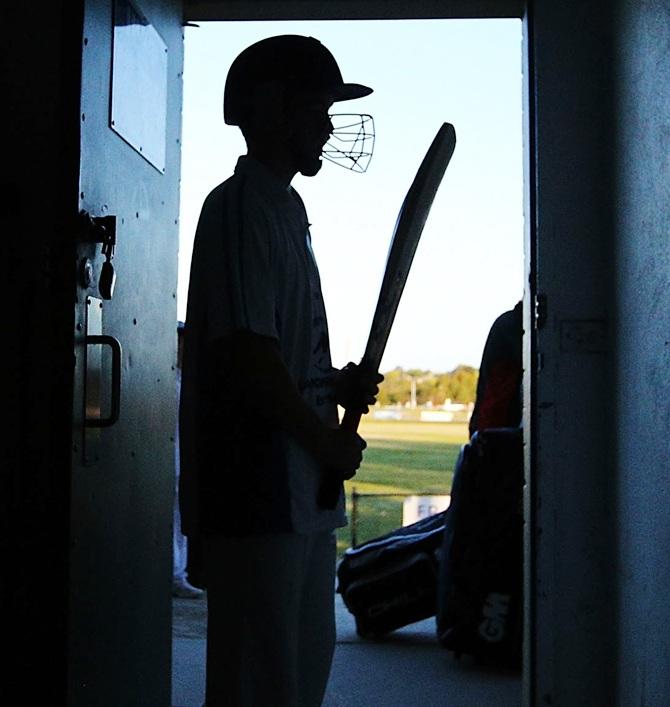 A cricketer for Langwarrin U/16 is seen wearing a helmet