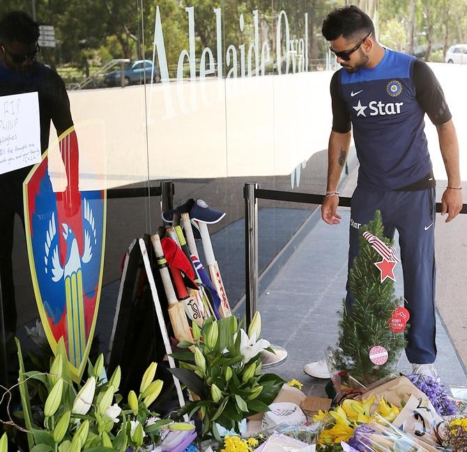 Virat Kohli of India leaves a bat and cap at a memorial for Phil Hughes