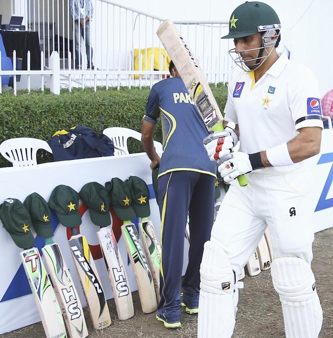 Misbah-ul-Haq of Pakistan walks past bats and caps placed outside the Pakistan dressing room in memory of Australian cricketer Phillip Hughes