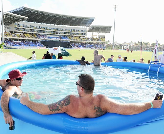 Cricket fans watch play from a swimming pool 
