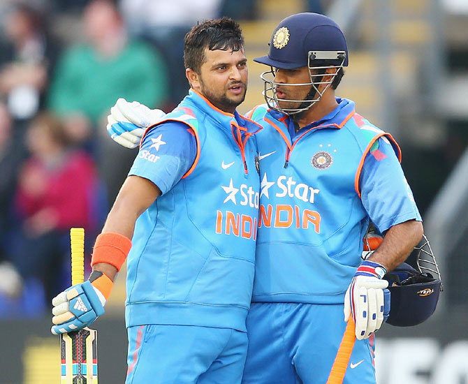 Suresh Raina (left) of India is congratulated by capatin MS Dhoni after reaching his century in Cardiff