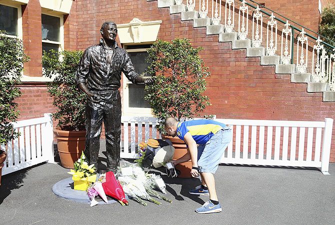 Tributes are placed at the statue of Richie Beanud at the Sydney Cricket Ground on Friday