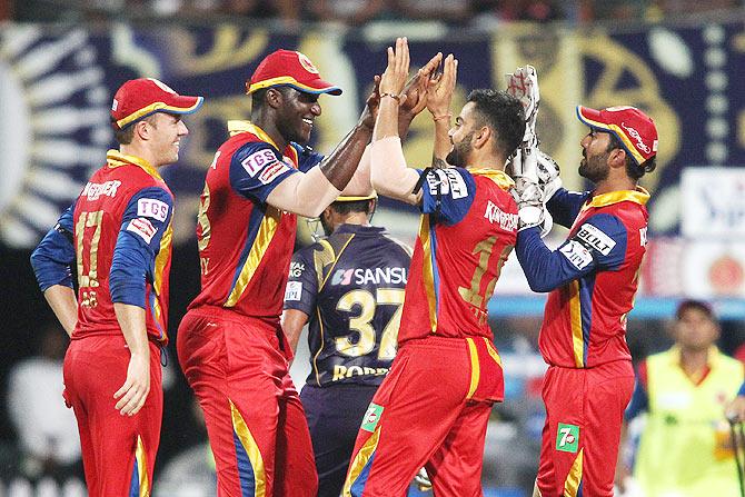 Darren Sammy of the Royal Challengers Bangalore is congratulated by captain Virat Kohli for taking the catch to dismiss Robin Uthappa of the Kolkata Knight Rider