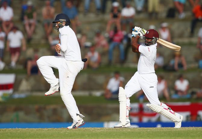 Darren Bravo of West Indies plays a shot as Joe Root of England takes evasive action