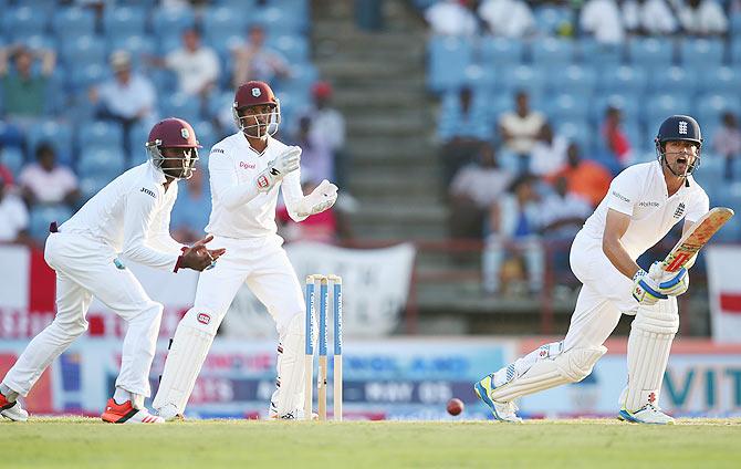 England's Alastair Cook plays a shot on the legside as West Indies wicketkeeper Denesh Ramdin and Jermaine Blackwood look on on Day 2 of the 2nd Test at the National Cricket Stadium in St George's in Grenada on Wednesday